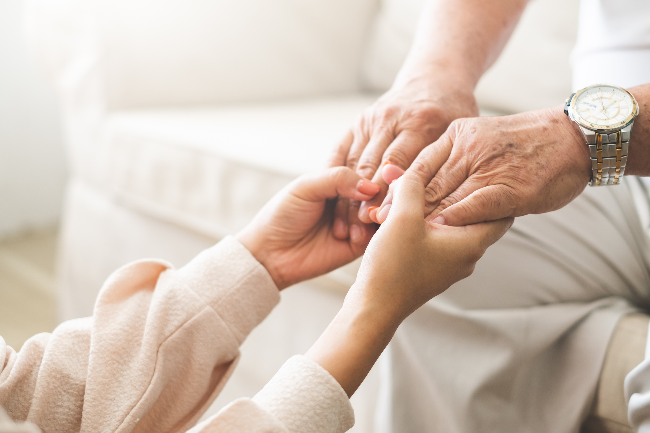 Woman hand holding old senior elder hand with love and care