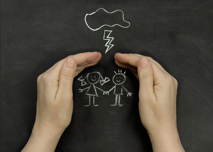 Hands protect children drawn on the blackboard. Concept of safety and protection of children.