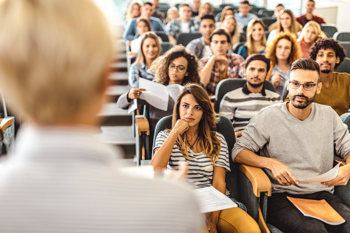 College students listening to their professor in a lecture hall.